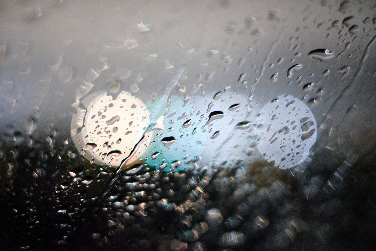 Raindrops on a window with soft background light