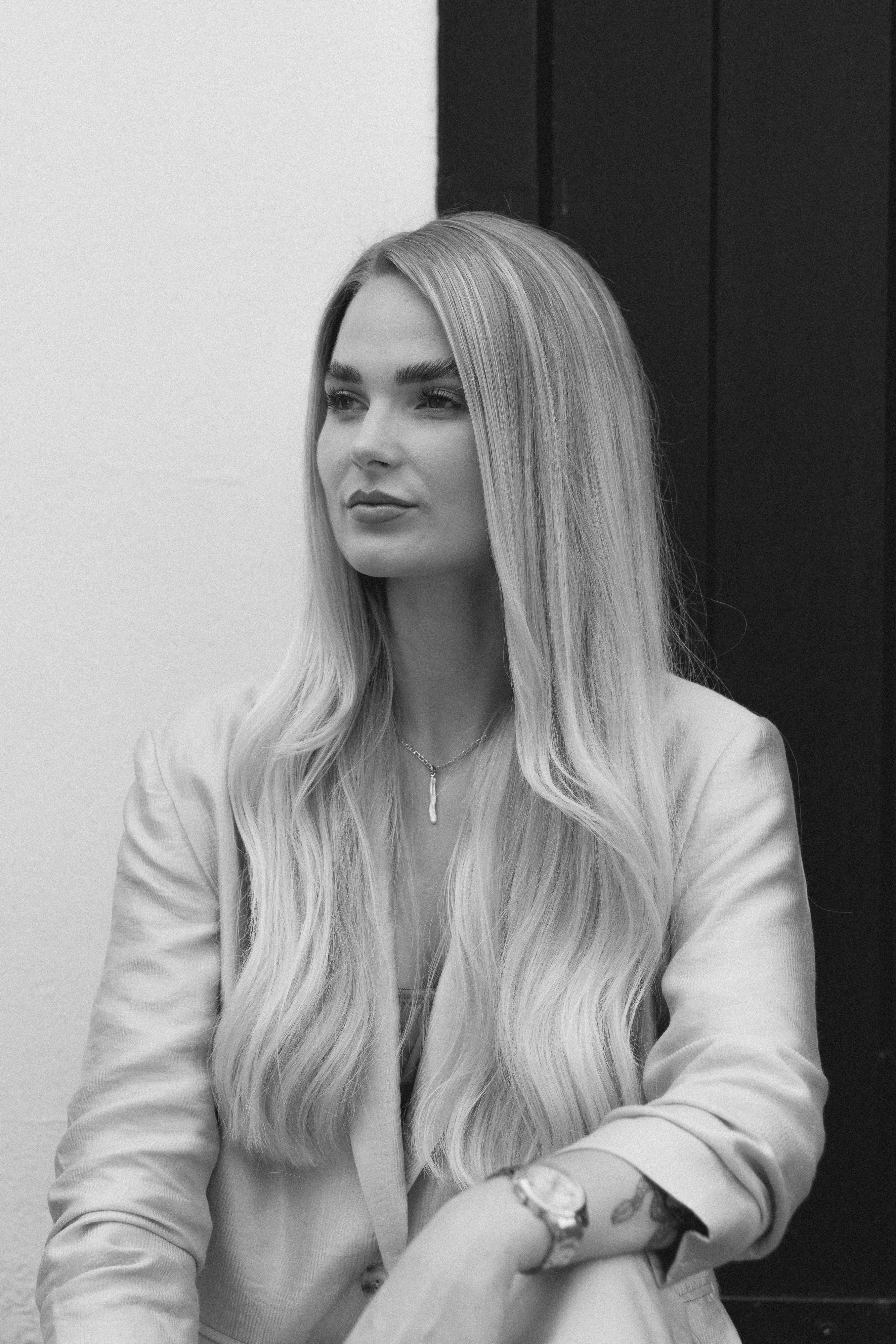 Graceful black and white portrait of a stylish woman with long blonde hair in London.