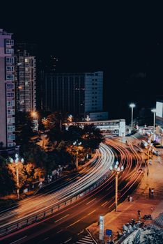Captivating night view of Panzhihua, China with vibrant light trails and urban cityscape.