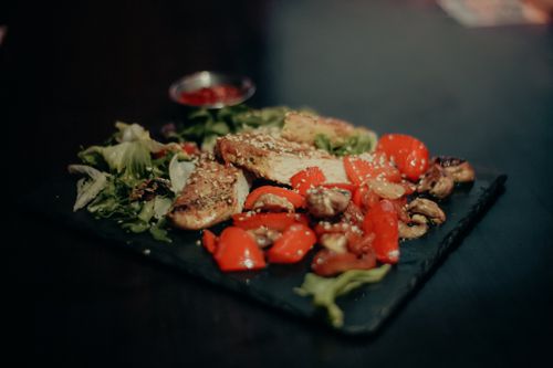 Free Savor a savory dish of grilled chicken with vibrant peppers, mushrooms, and greens. Stock Photo