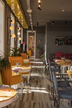 Sunlight streaming through a chic cafe with colorful seating and modern decor.
