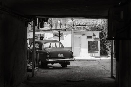 A classic GAZ-21 car parked in a shaded urban alleyway, capturing a nostalgic city scene.