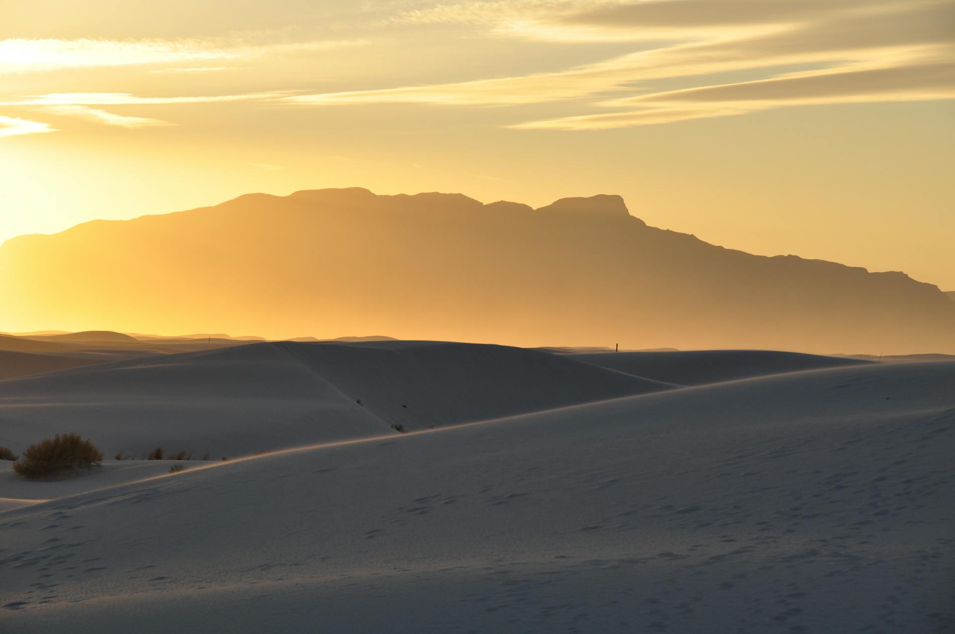 Stunning sunset view of White Sands dunes in New Mexico with a golden sky.