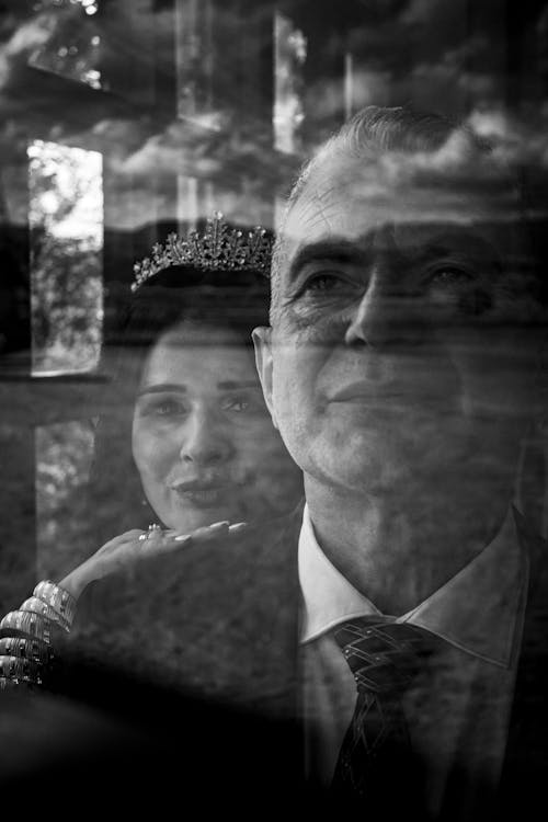 Man and Woman in Crown behind Window