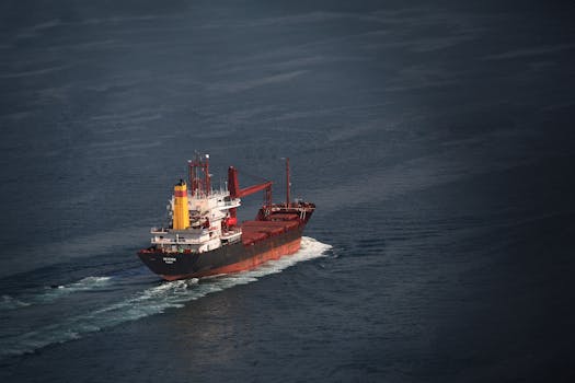An aerial view of a large cargo ship sailing across the ocean.