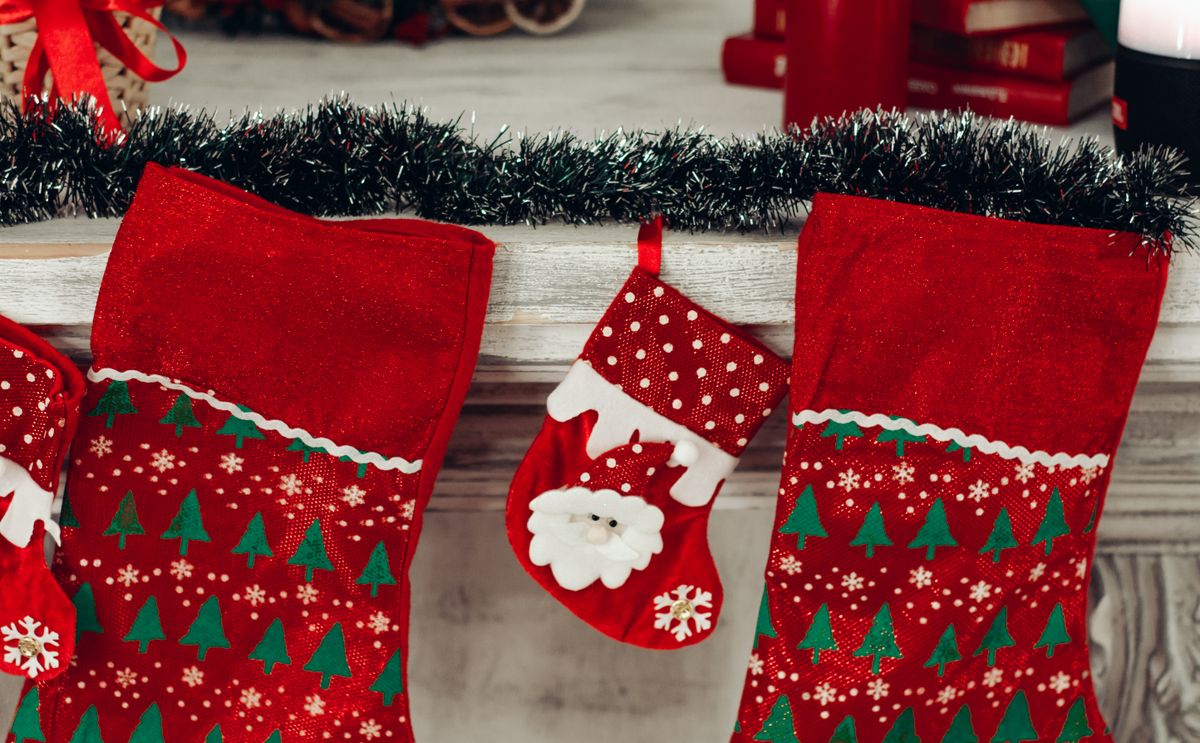 Colourful Christmas stockings hanging on a decorated mantlepiece