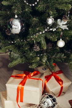 圣诞树上装饰着银色饰品和用红丝带包裹的礼物