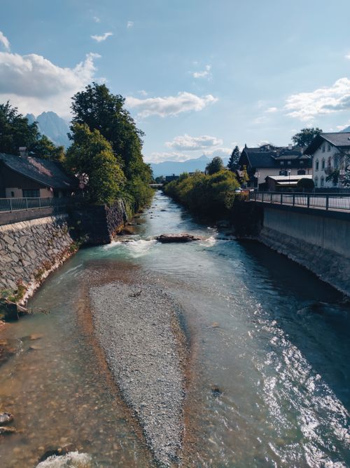 Free Picturesque river flowing through Garmisch-Partenkirchen, Germany in summer with houses and trees lining the banks. Stock Photo