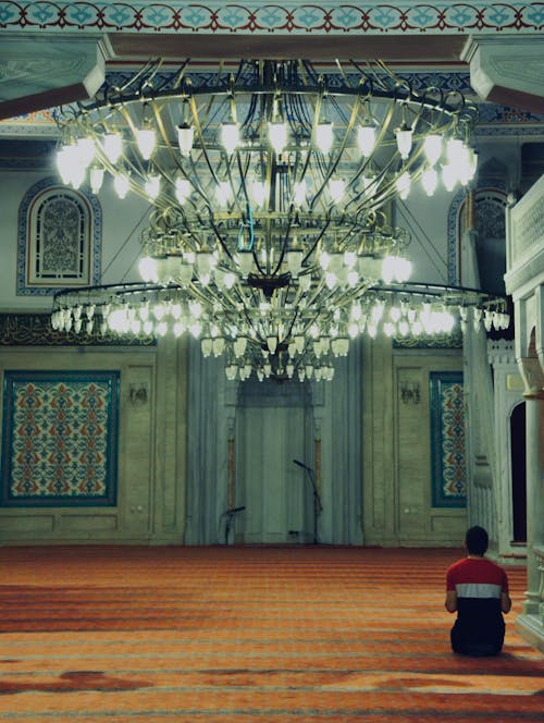 Back View of a Man Sitting on the Floor and Praying in a Mosque 