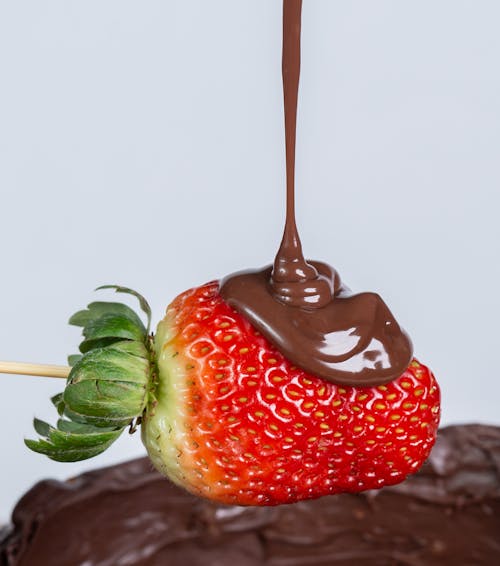 Close-up of Chocolate Being Poured on a Strawberry 