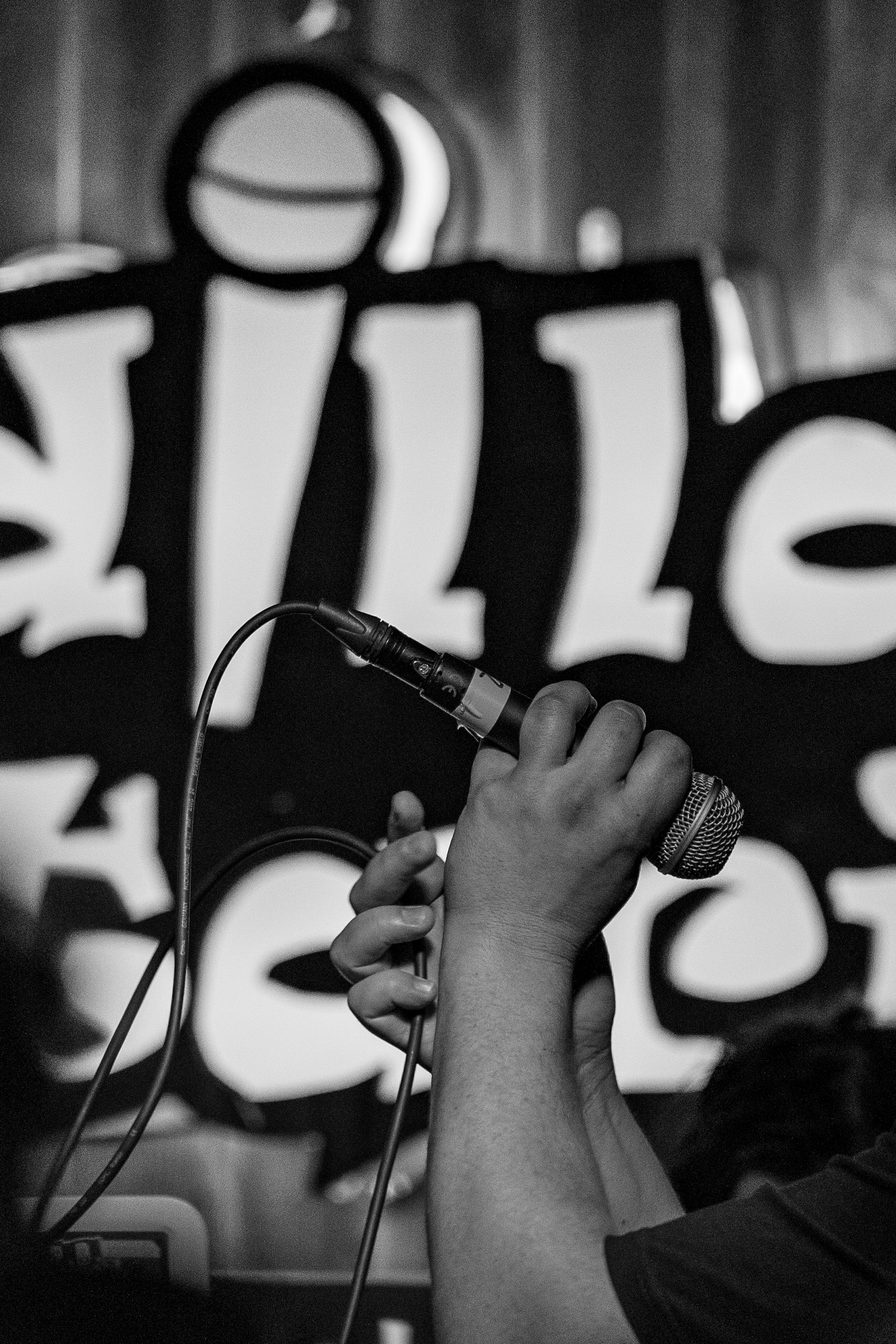 Black and white image of hands gripping a microphone during a performance in Madrid.