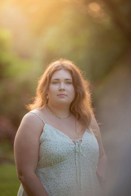 Free A serene portrait of a woman outdoors in a sunlit scene, exuding tranquility. Stock Photo