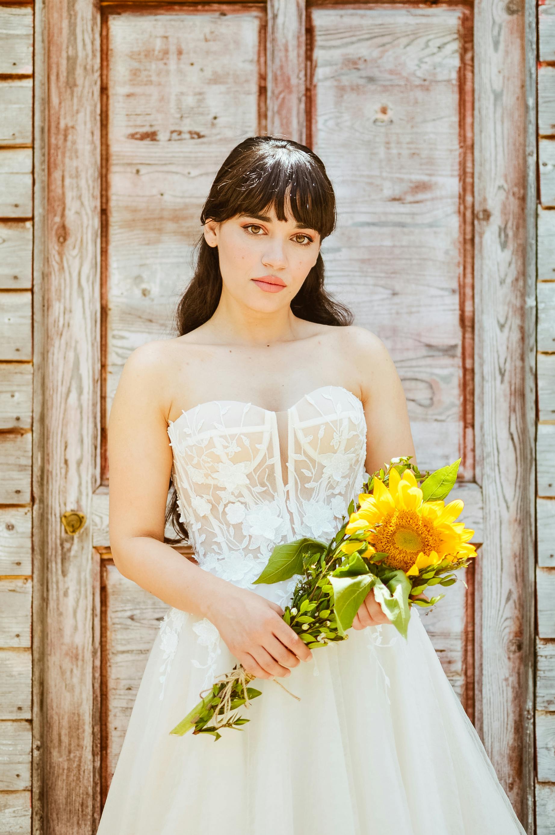 a bride posing against wooden wall