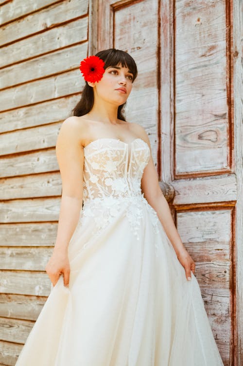 Woman in Wedding Dress and with Red Flower