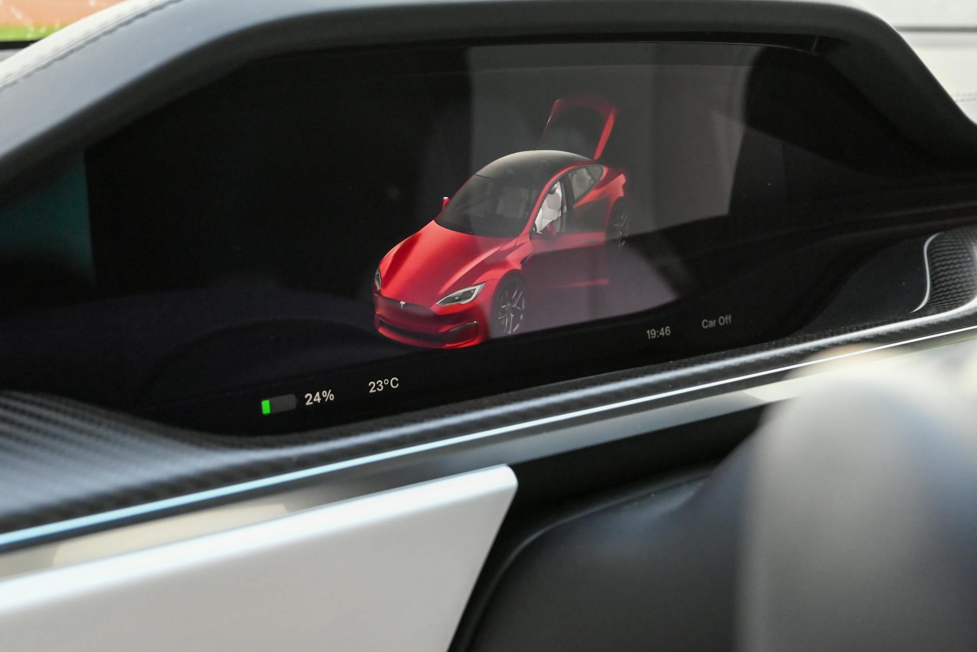 Close-up of a Tesla's dashboard showing the car's status on a digital screen.