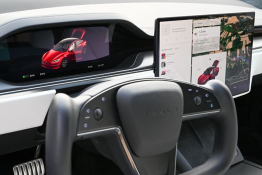 Explore the sleek interior of a modern electric car featuring advanced touchscreens and innovative steering design.