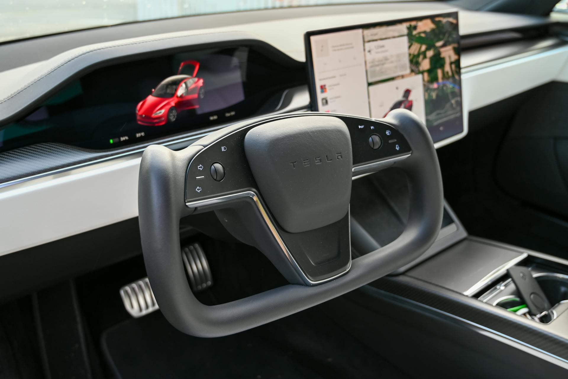 Explore the cutting-edge design of the Tesla car interior featuring a futuristic steering wheel and advanced touchscreen displays.