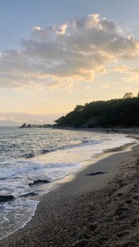Calm beach scene with soft waves and sunset sky, ideal for relaxation themes.
