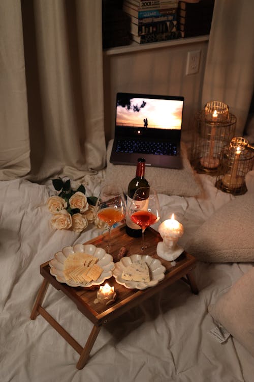 Wine and Snacks with Flowers on Bed
