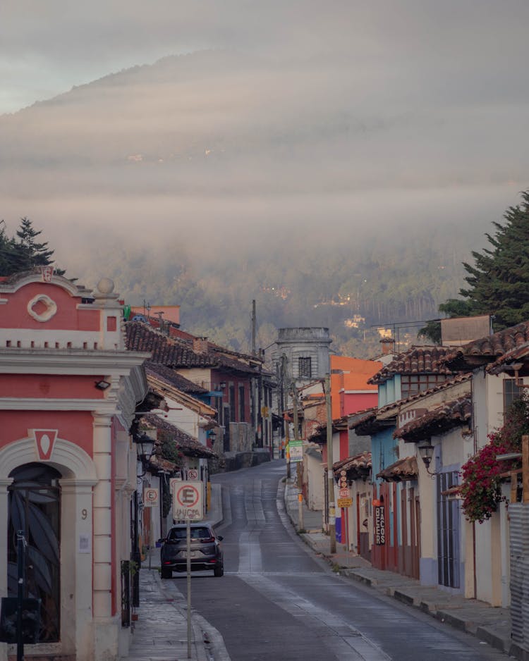 Town Buildings With Hill Under Clouds Behind