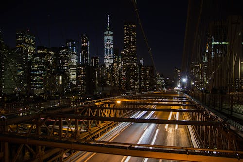 бесплатная Покадровая съемка движущегося транспортного средства на мосту ночью Стоковое фото