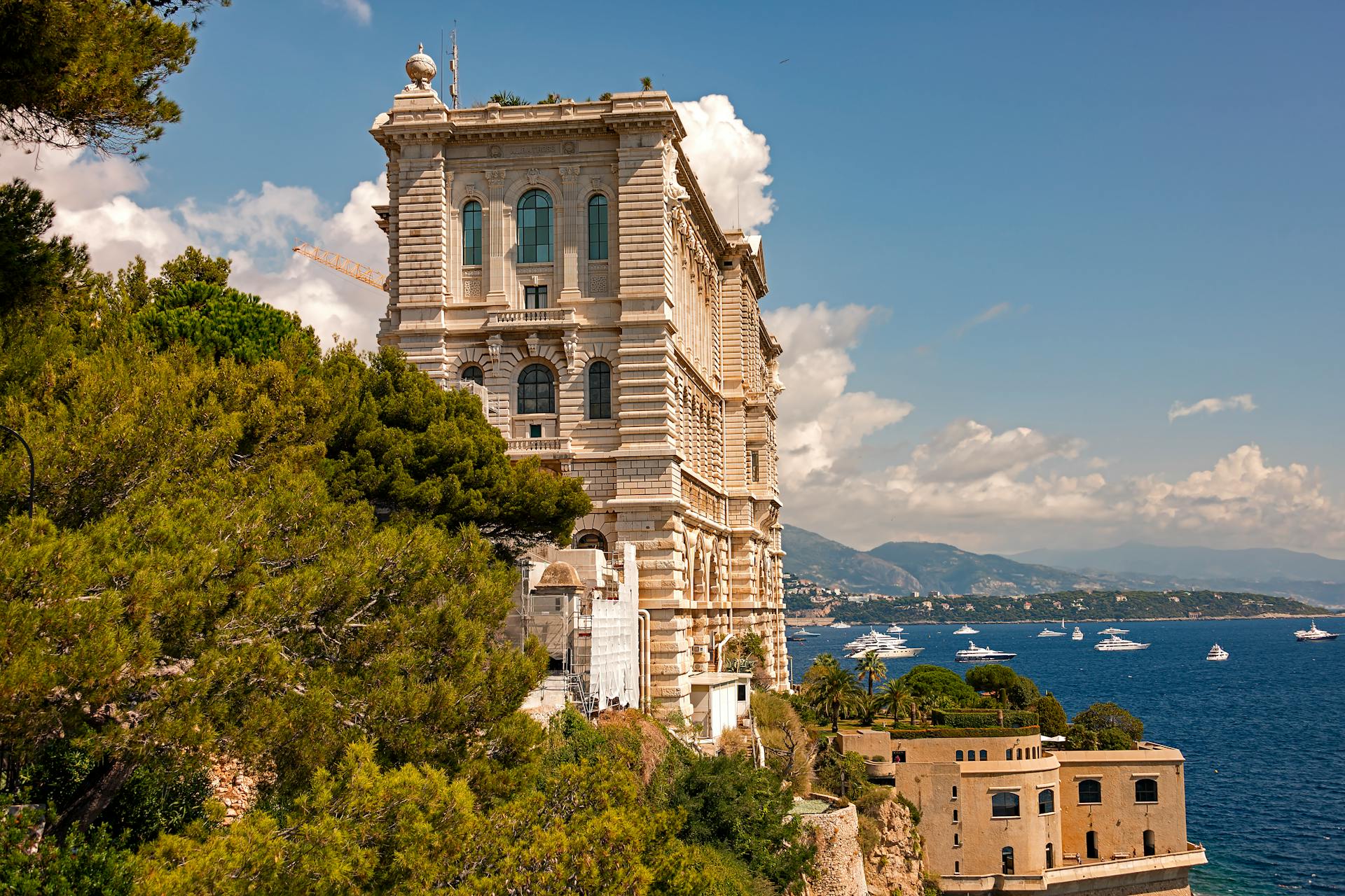 The Oceanographic Museum in Monaco with a stunning coastal view, surrounded by greenery and the Mediterranean Sea.