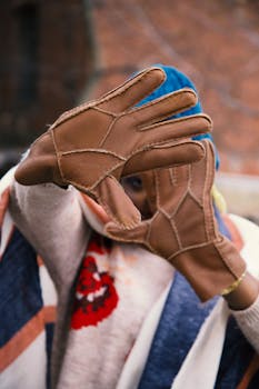 Stylish winter portrait featuring a woman framing face with leather gloves.