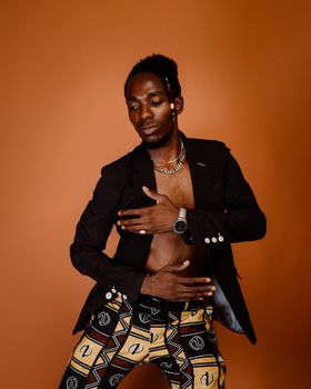 Fashion portrait of a stylish man posing with a confident expression in a studio setting.