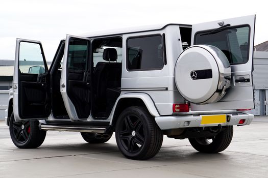 Silver Mercedes SUV with open doors parked outdoors, showcasing luxury and design.