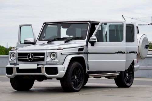 Free Elegant silver Mercedes-Benz G-Class SUV parked outdoors with doors open. Stock Photo