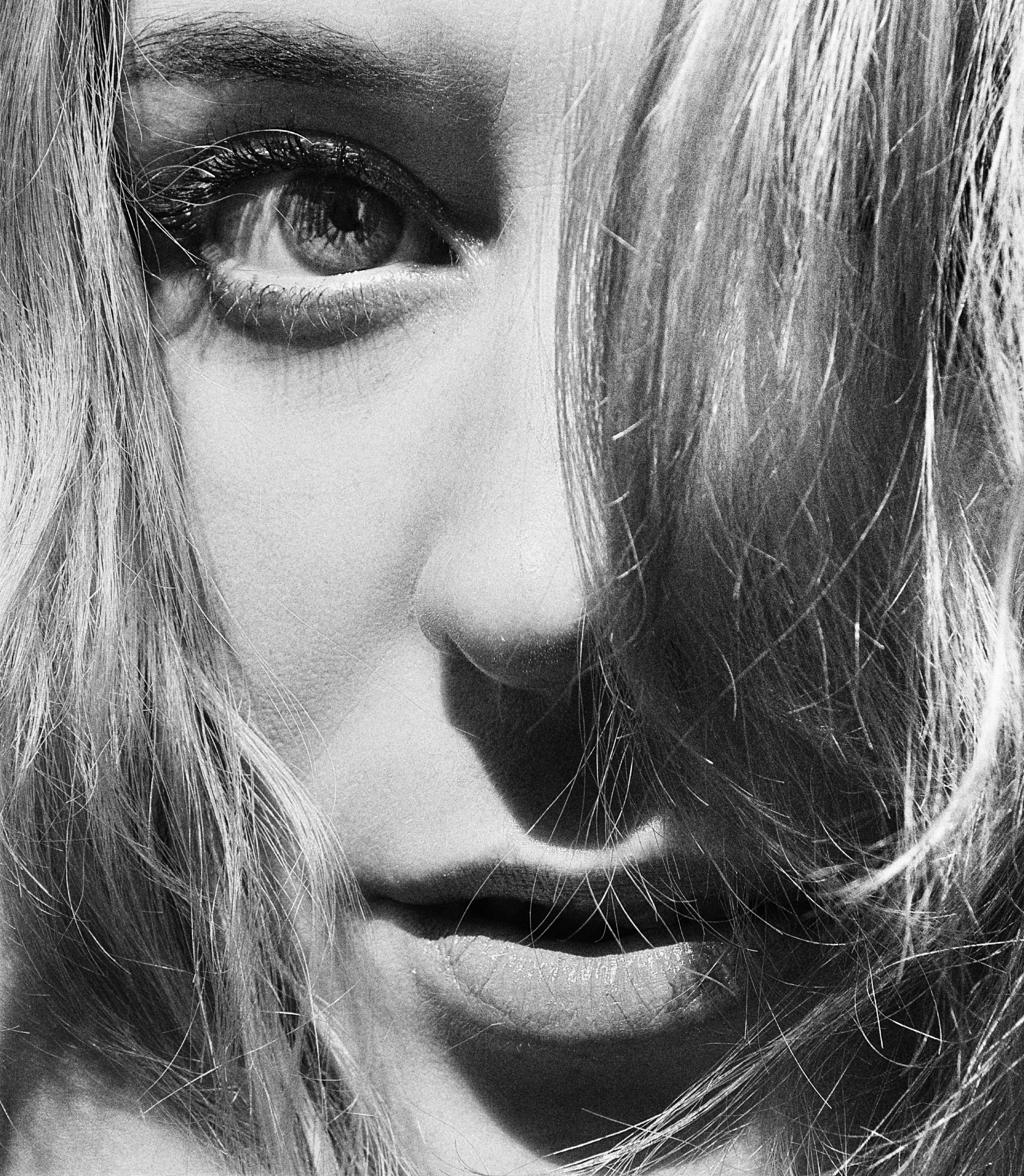 Black and white close-up portrait of a woman's face with expressive eyes.
