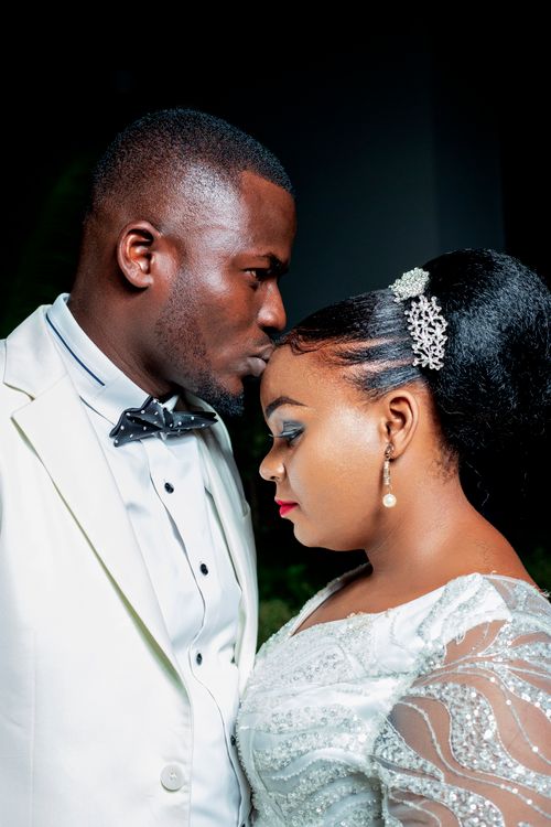 Free A beautiful African American couple sharing a tender moment in their wedding attire. Stock Photo