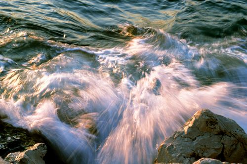 Free Captivating image of ocean waves splashing against rocky shore during sunset, showcasing vibrant motion and colors. Stock Photo