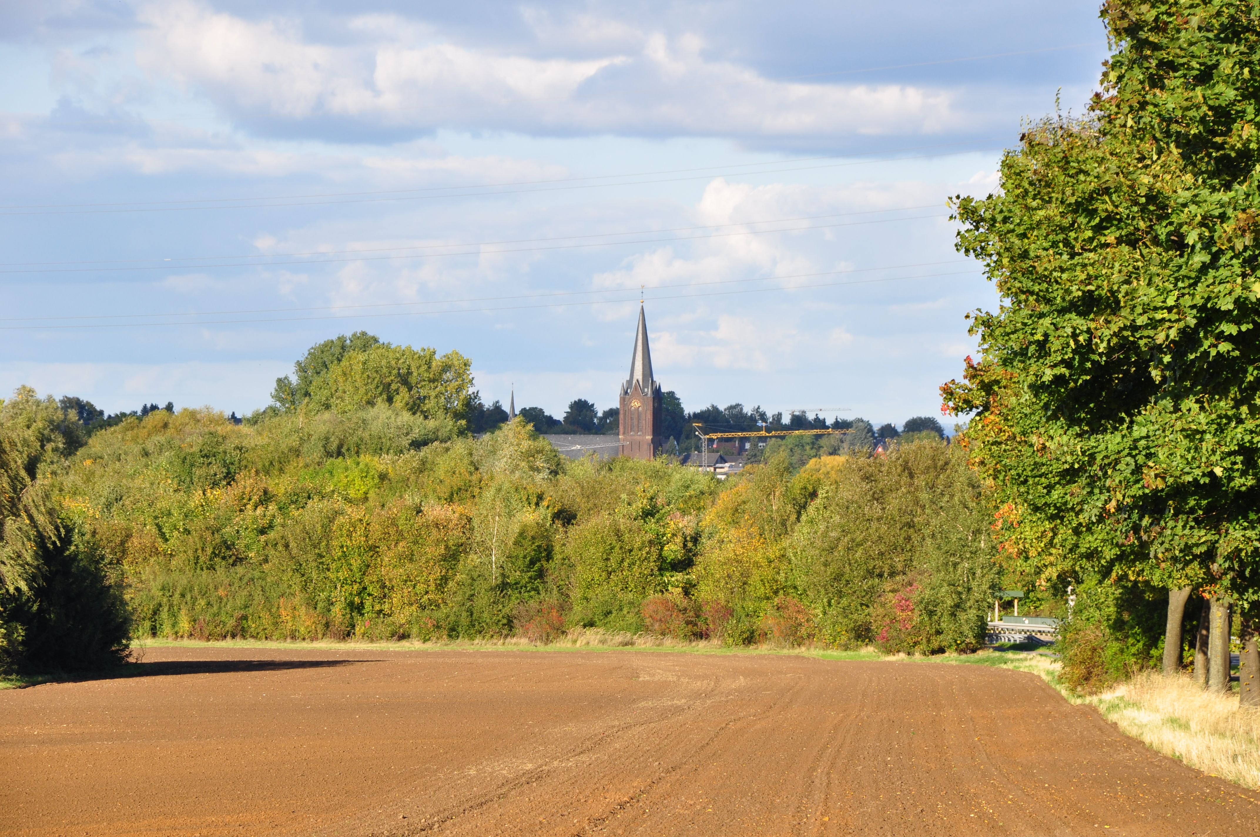 Willow-lined Kromme Rijn footpath with a village church tower ahead