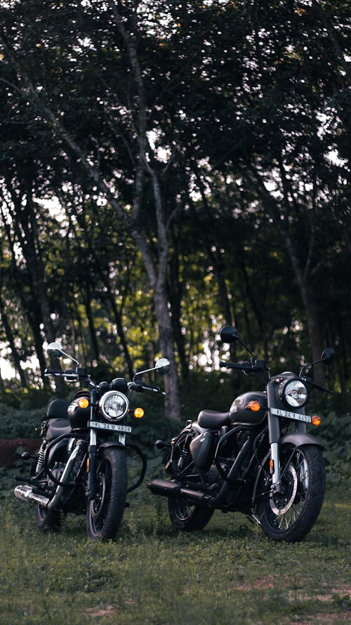 Two Royal Enfield Motorcycles Parked on the Grass