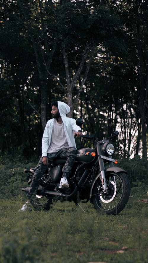 A Bearded Man in a Hoodie Sitting on a Motorcycle 