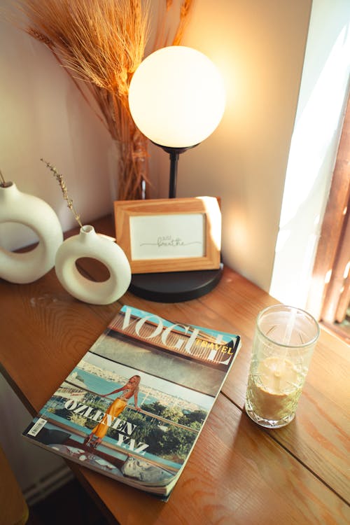 Fashion Magazine and Coffee in Glass on Table