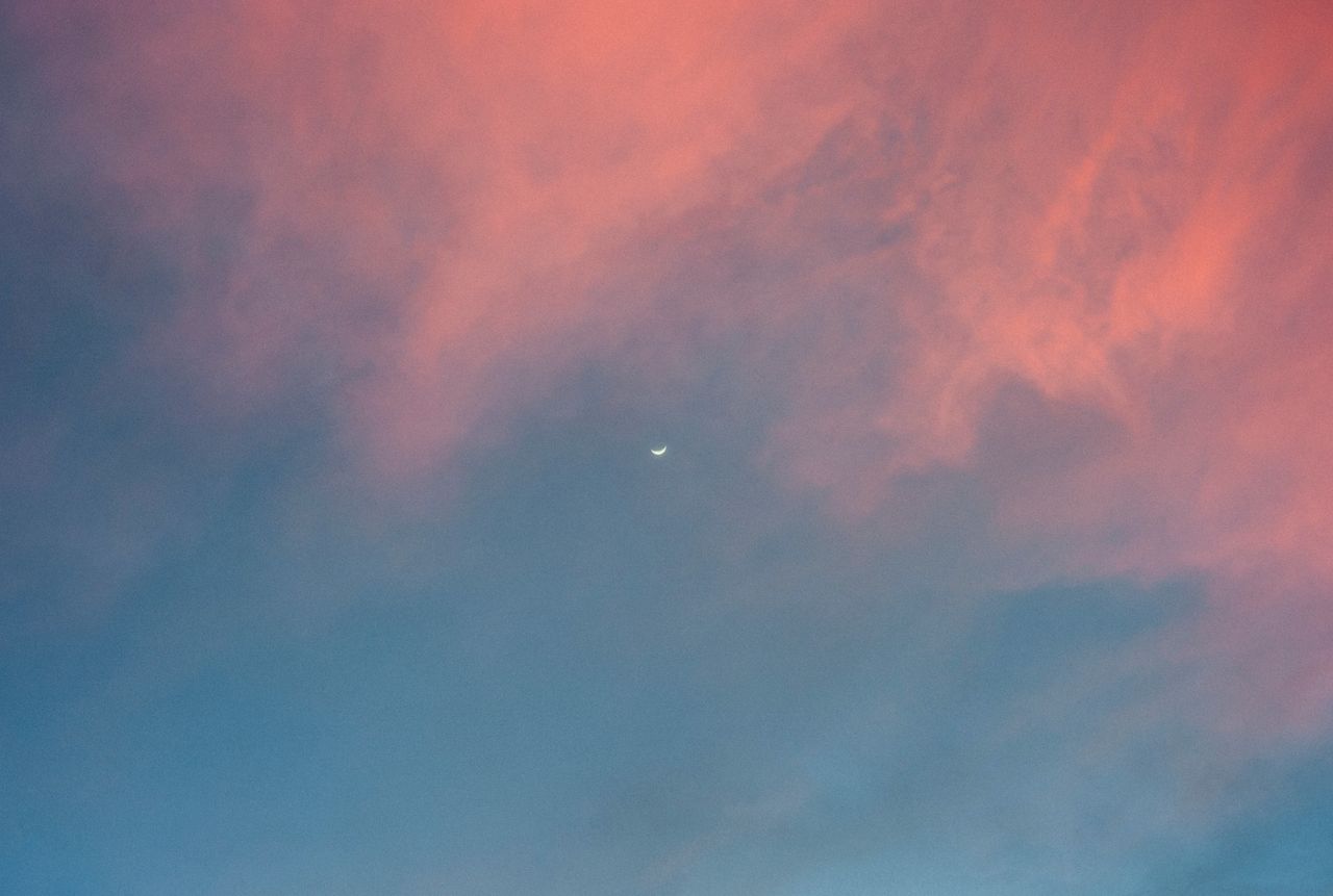 a serene pastel sky featuring a crescent moon at twilight perfect for