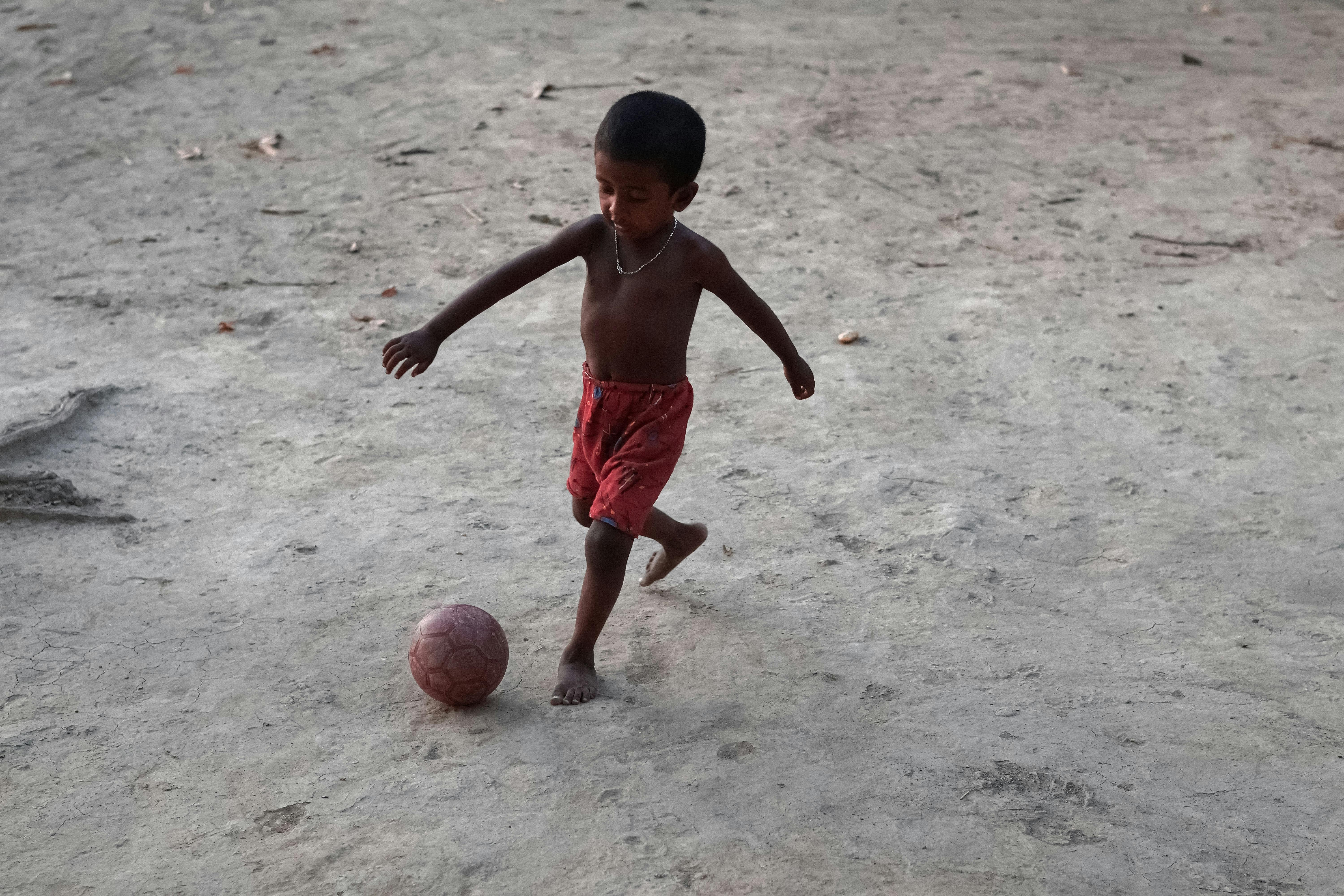 Little boy in a motion to kick the ball