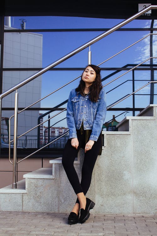 Woman in Jean Jacket Standing by Stairs