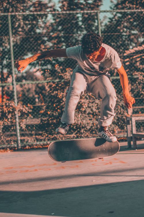 Free Teenager performs a skateboard trick outdoors. Captured in vibrant lighting. Stock Photo