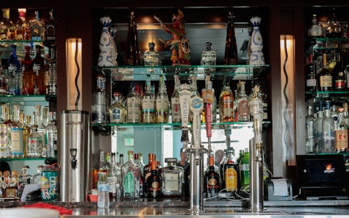 Alcohol Bottles on Shelves in Bar