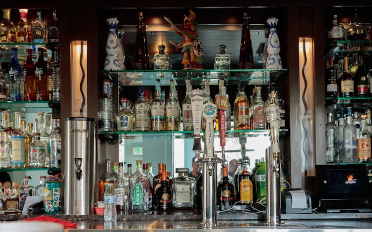 Alcohol Bottles On Shelves In Bar