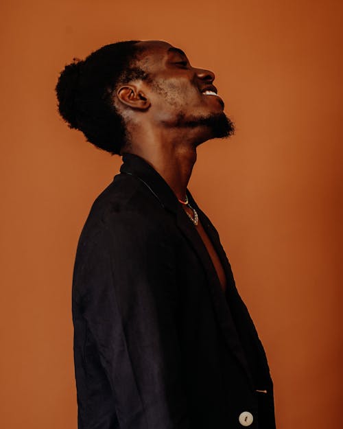 Studio Shoot of a Man Posing against Orange Brown Background