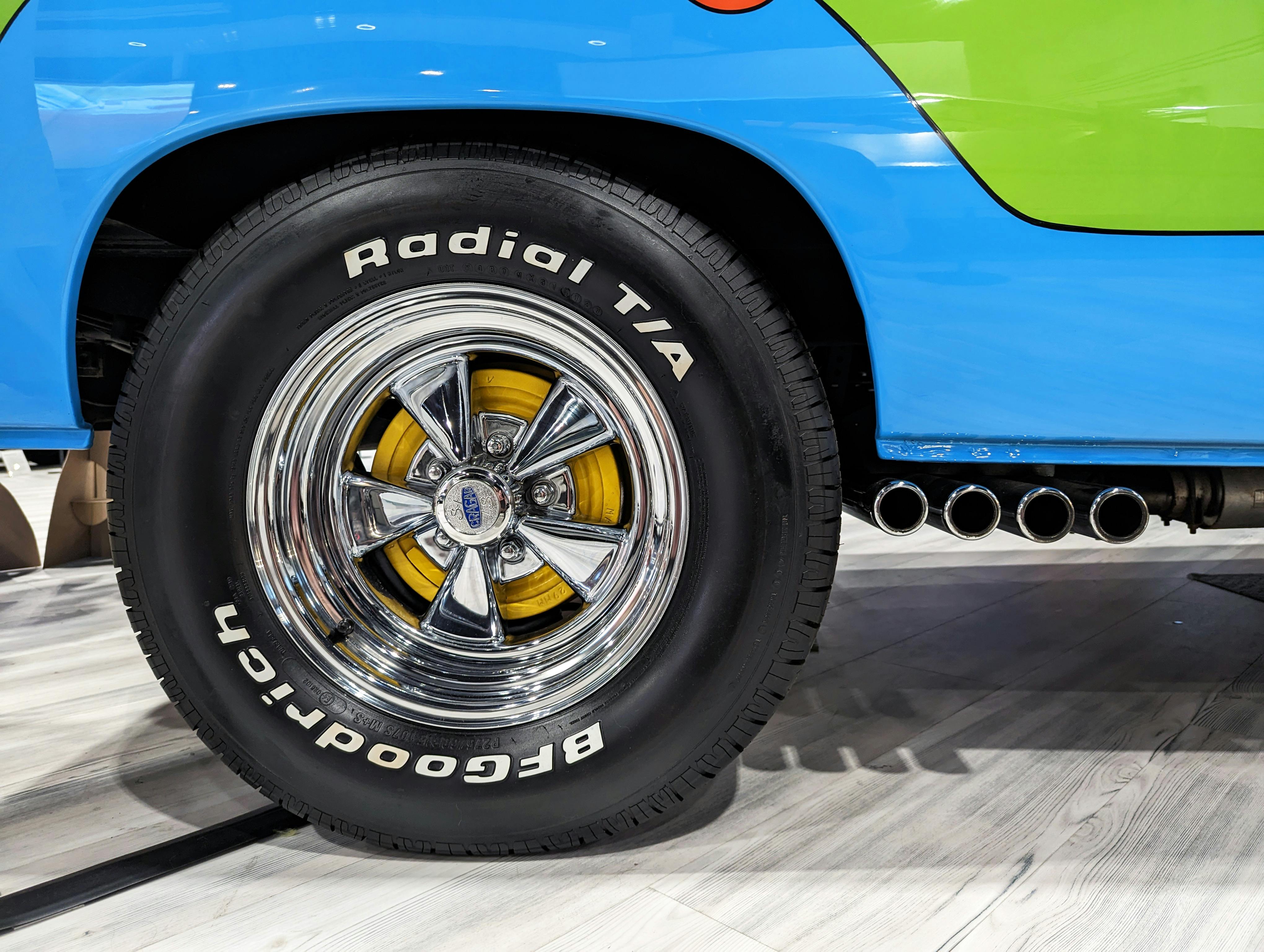 The wheel of a blue and green truck with a tire · Free Stock Photo