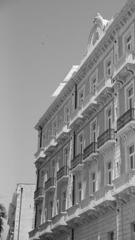 Black and white photo of a detailed historical building facade with balconies and windows.