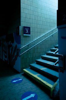 Staircase in an urban setting with directional floor arrows and spot indicators.
