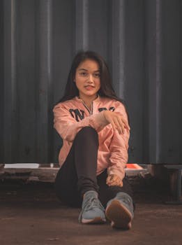 一位身着休闲装的年轻女子在户外自信地摆着姿势，表情轻松