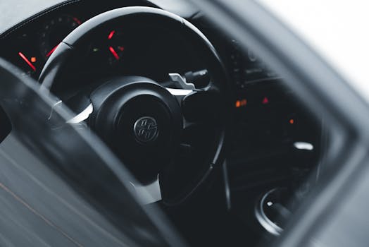 A detailed view of a car's steering wheel and dashboard, emphasizing modern automotive design.