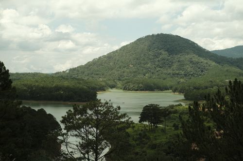 Free Aerial view of lush green hills and serene river under cloudy sky, perfect for nature lovers. Stock Photo